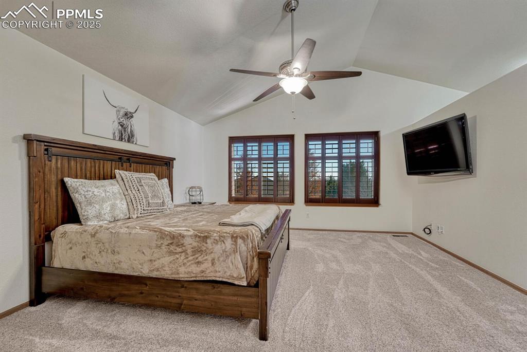 Image 26 of 50: Bedroom with carpet floors, lofted ceiling, and ceiling fan