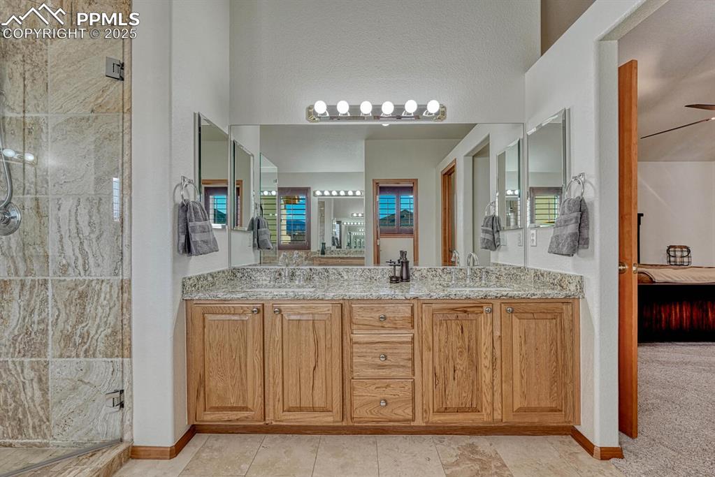 Image 29 of 50: Full bath with ensuite bath, a stall shower, and double vanity