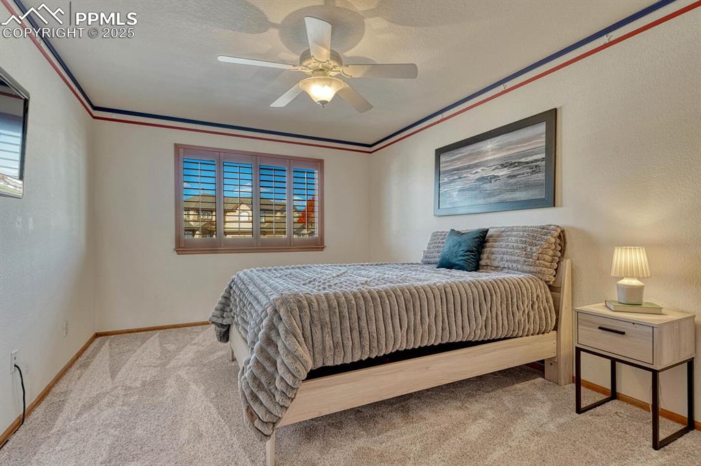 Image 31 of 50: Bedroom with crown molding, light carpet, a textured ceiling, ceiling fan, 