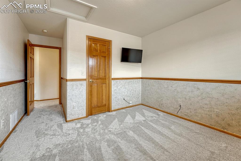 Image 32 of 50: Unfurnished bedroom featuring attic access and carpet flooring