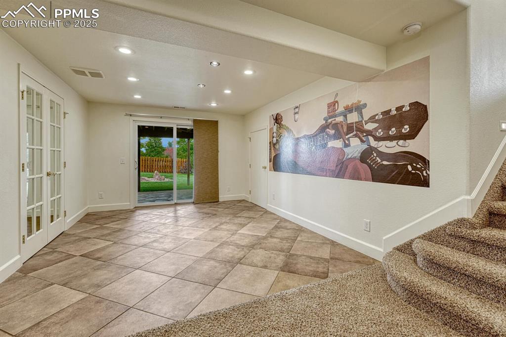Image 34 of 50: Carpeted spare room with recessed lighting, french doors, tile patterned fl