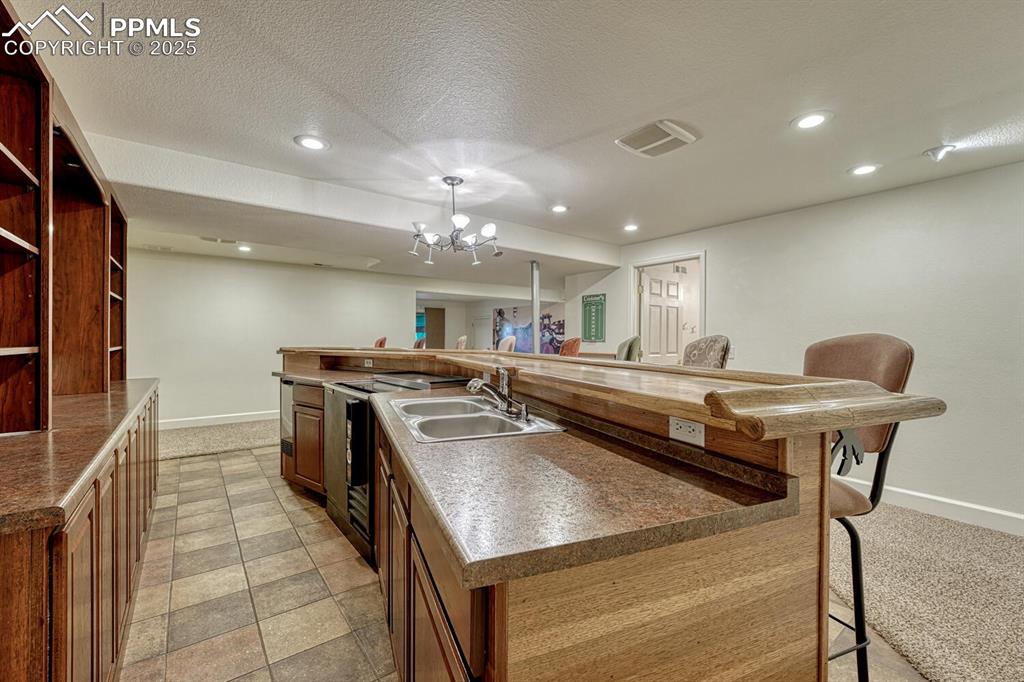 Image 38 of 50: Kitchen with a kitchen breakfast bar, a large island with sink, recessed li