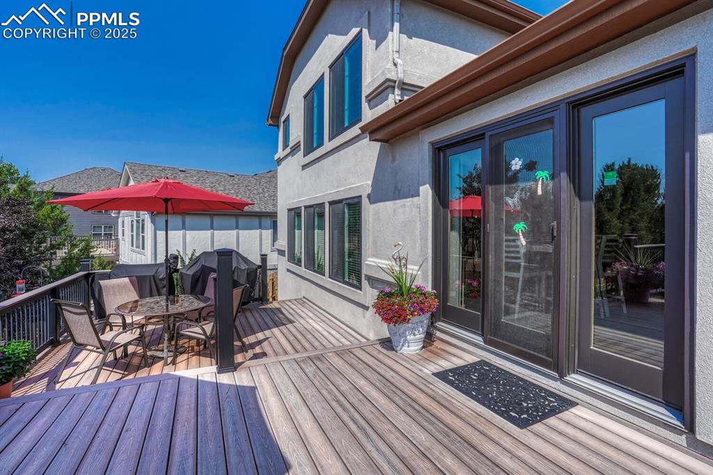 Image 43 of 50: Deck with outdoor dining area and a grill
