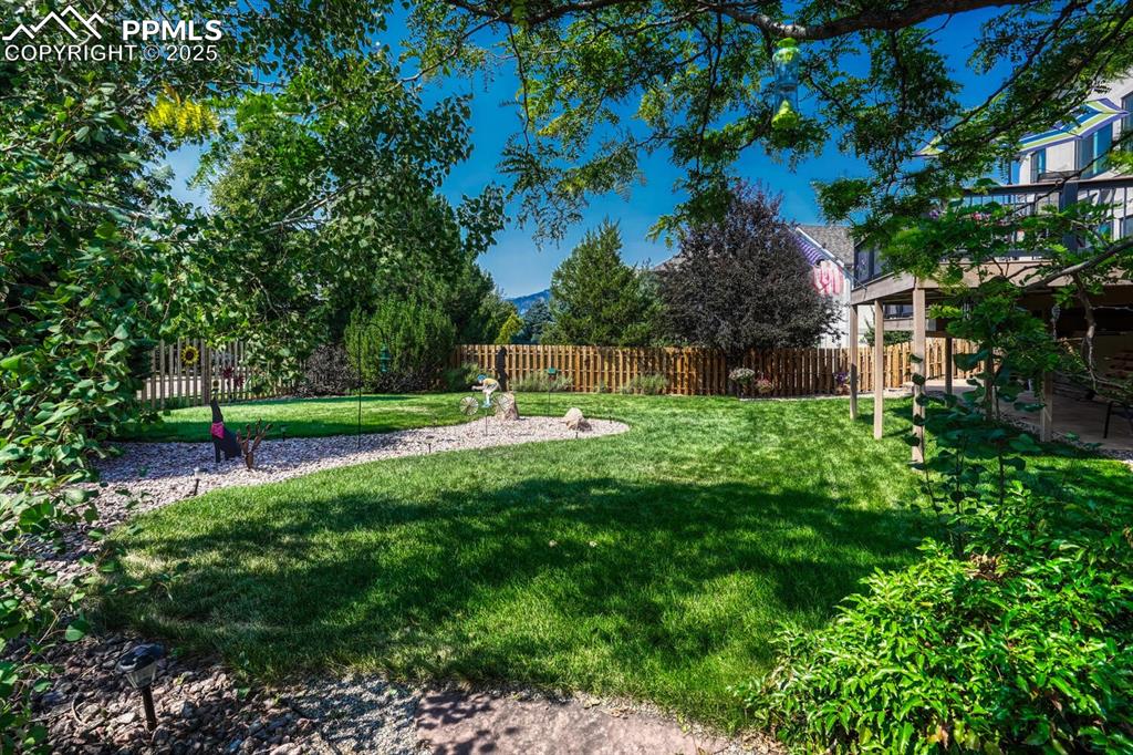 Image 46 of 50: Fenced backyard with a patio