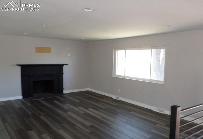 Image 5 of 22: Unfurnished living room with a fireplace with flush hearth, baseboards, rec