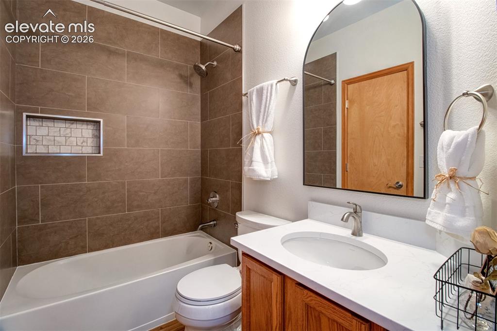 Image 18 of 37: Lovely main-level full bath can be accessed from hallway AND the primary su