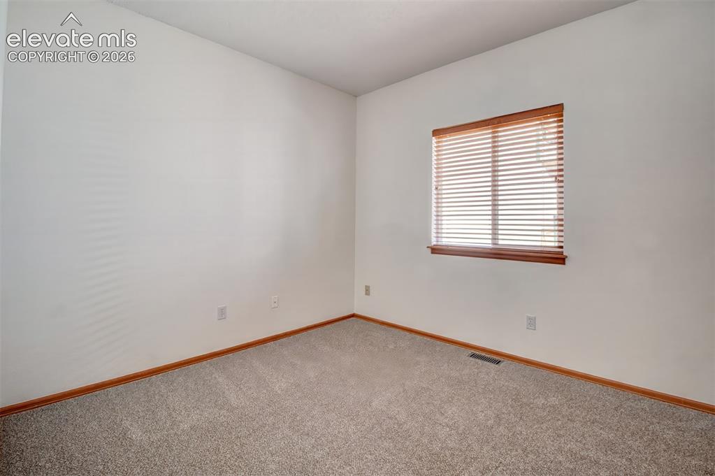 Image 20 of 37: Another view of main-level secondary bedroom.