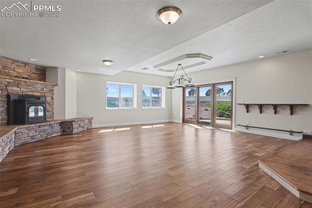 Image 32 of 50: Basement Walk-Out Family Room w/Pellet Stove and Vintage Bar