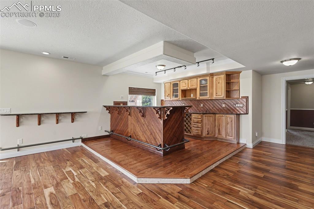 Image 34 of 50: Basement Walk-Out Family Room w/Pellet Stove and Vintage Bar