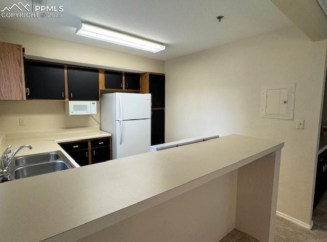 Image 14 of 32: Kitchen featuring white appliances, light countertops, stainless sink, and 