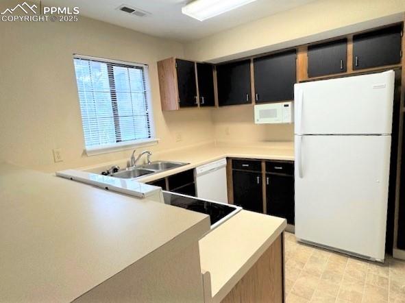Image 15 of 32: Kitchen with white appliances, light countertops, and a lovely 2-tone color