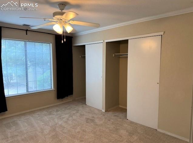 Image 17 of 32: Main bedroom with two closets, crown molding, ceiling light fixture with ce