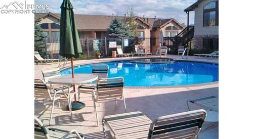 Image 34 of 36: Community pool featuring lots of patio space