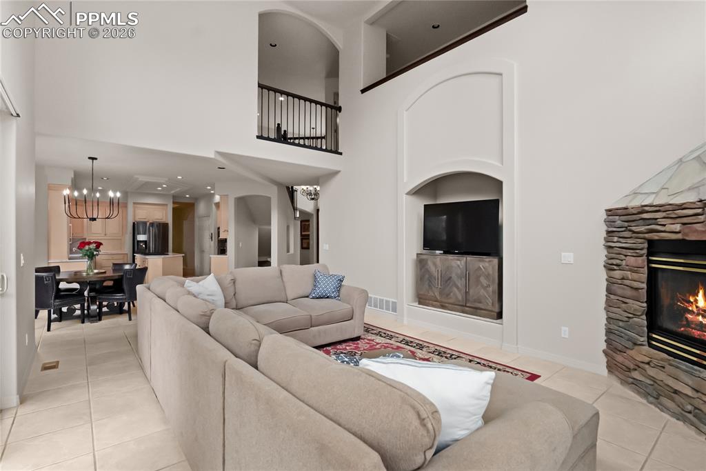 Image 16 of 40: Living room with vaulted ceilings and a fireplace.