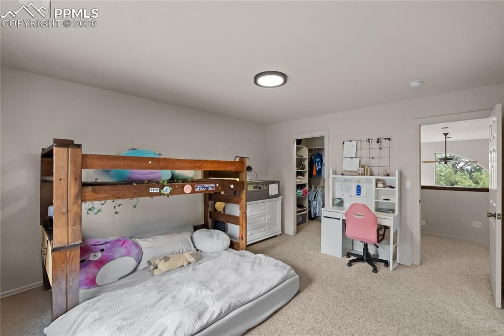 Image 27 of 40: Third bedroom with walk in closet, bookshelf and jack and Jill bathroom.