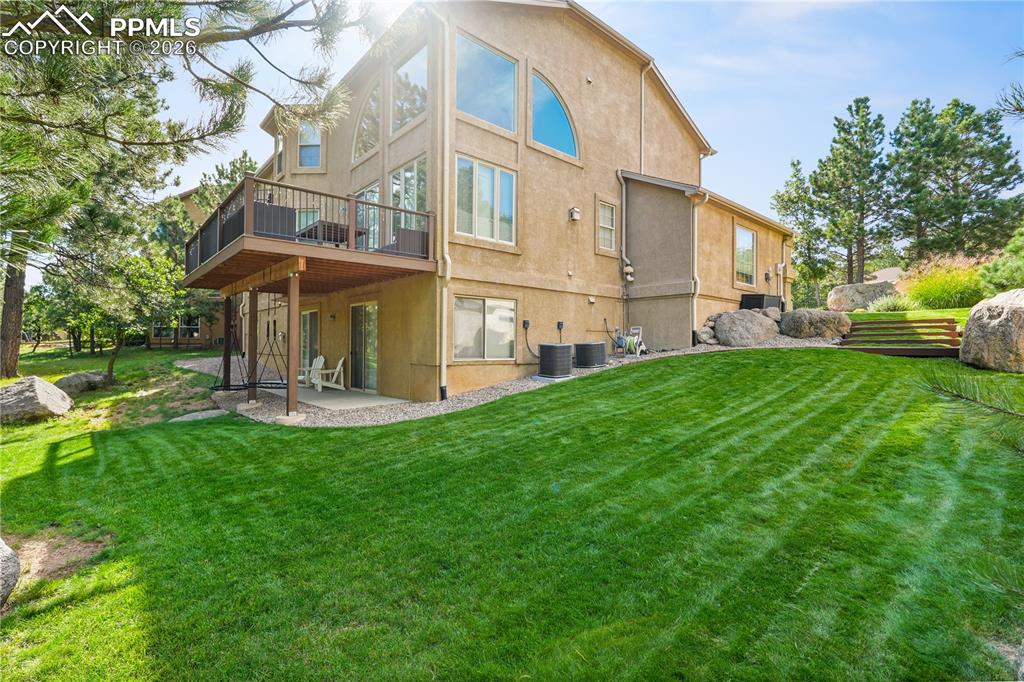 Image 3 of 40: Trex deck, boulders, mature trees.