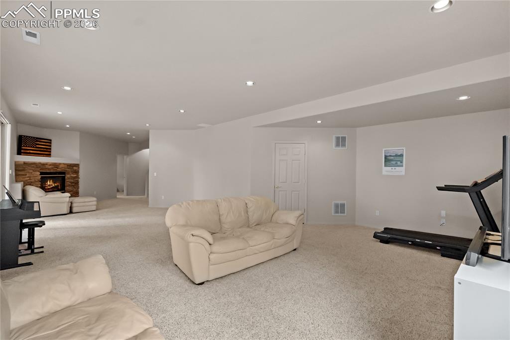 Image 31 of 40: Basement family room with fireplace.