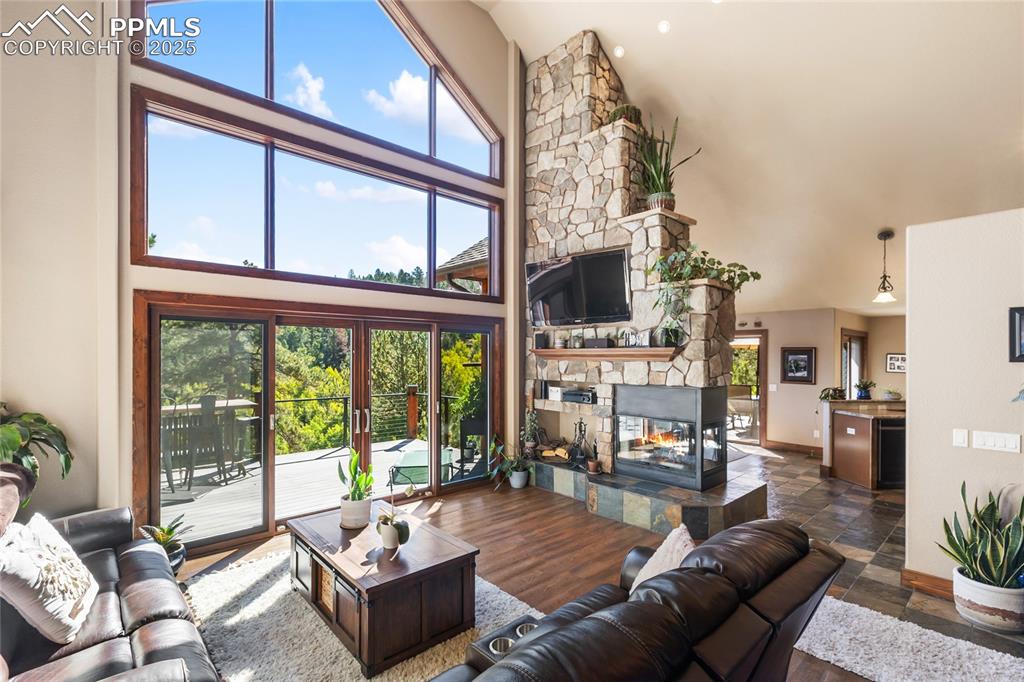 Image 8 of 38: Look at those floor to ceiling windows and 2 sided wood burning fireplace!