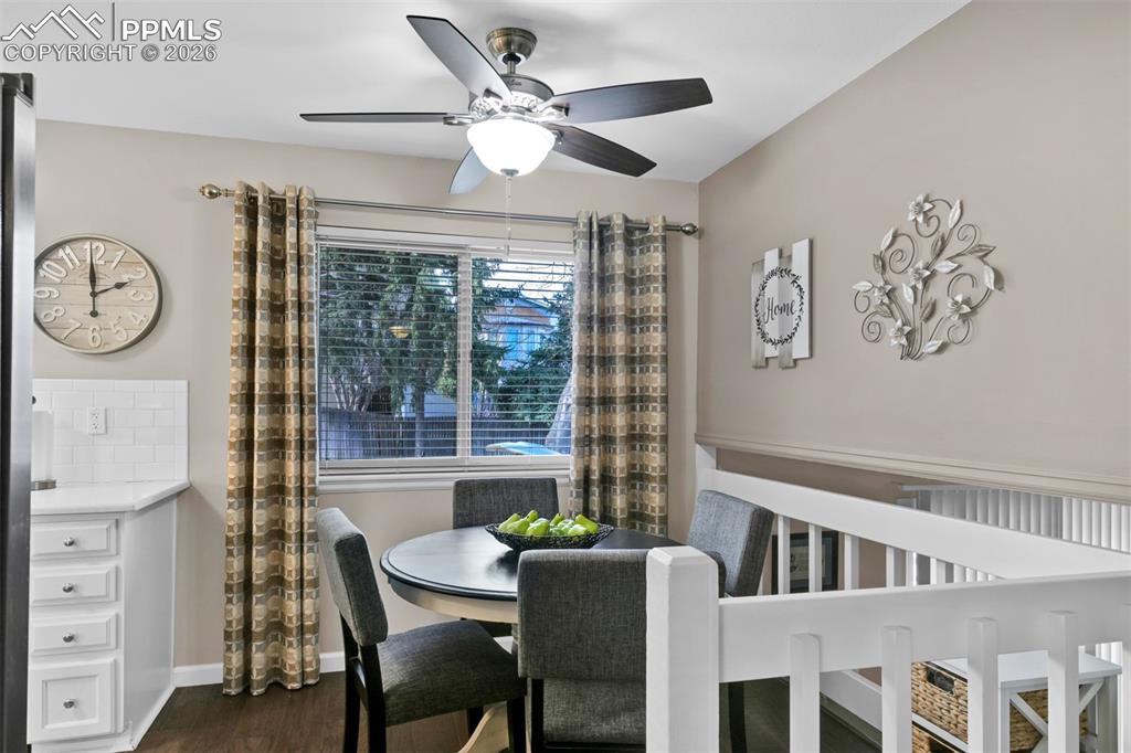Image 22 of 41: Dining space with dark wood-style floors and a ceiling fan