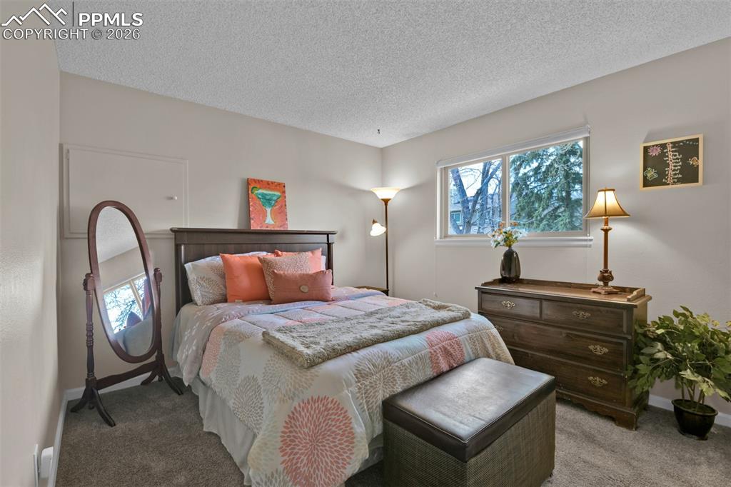Image 25 of 41: Carpeted bedroom featuring a textured ceiling and baseboards