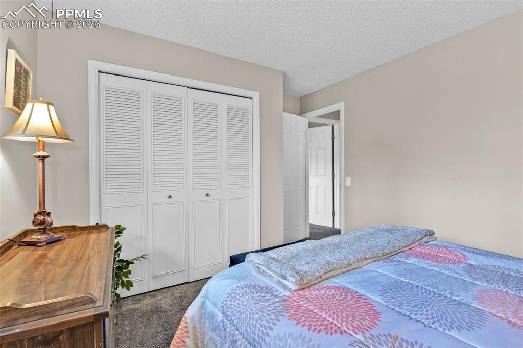 Image 26 of 41: Carpeted bedroom with a textured ceiling and a closet