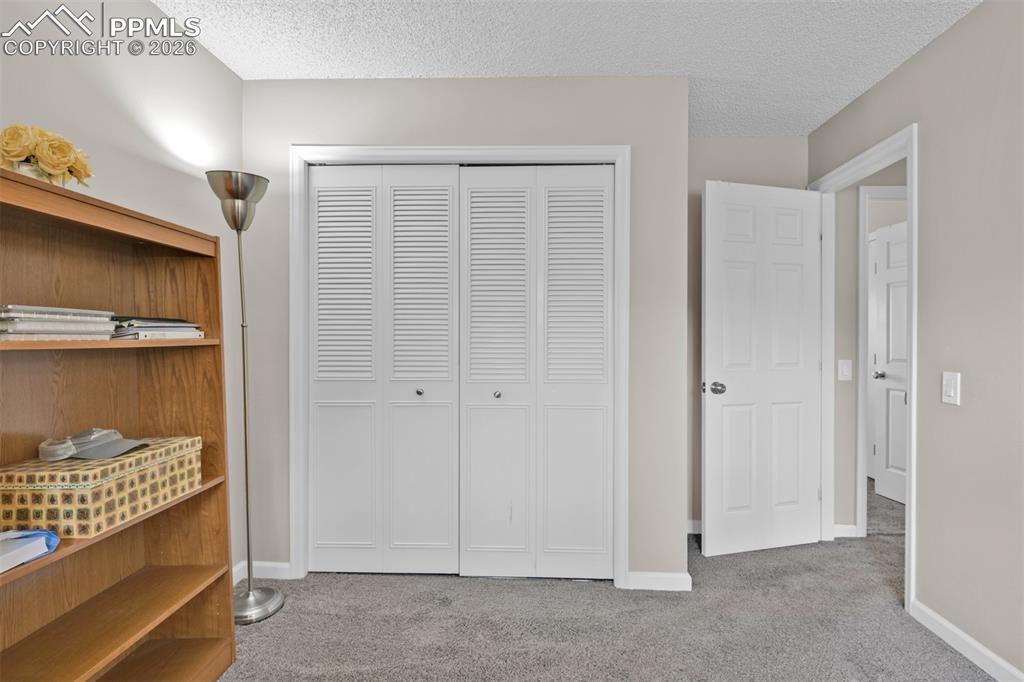Image 27 of 41: Bedroom with light colored carpet, a textured ceiling, and a closet