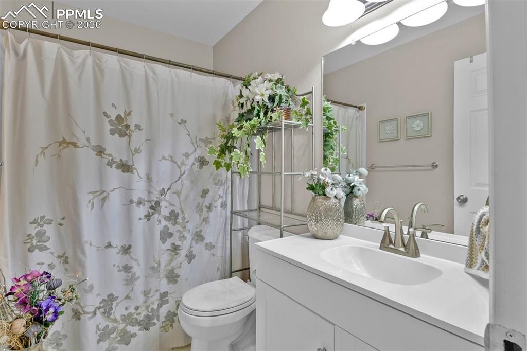 Image 28 of 41: Full bath with vanity and a shower with shower curtain