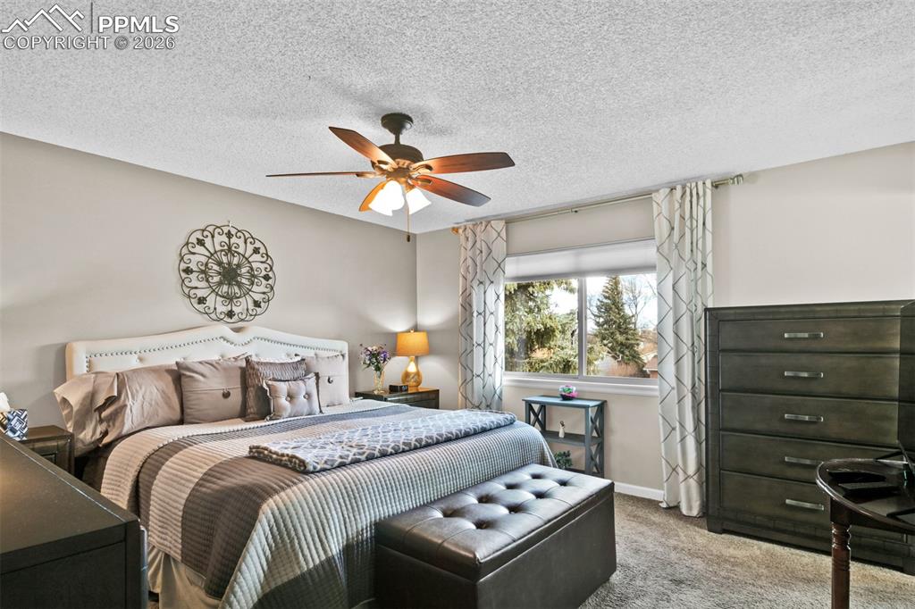 Image 34 of 41: Carpeted bedroom with a ceiling fan and a textured ceiling
