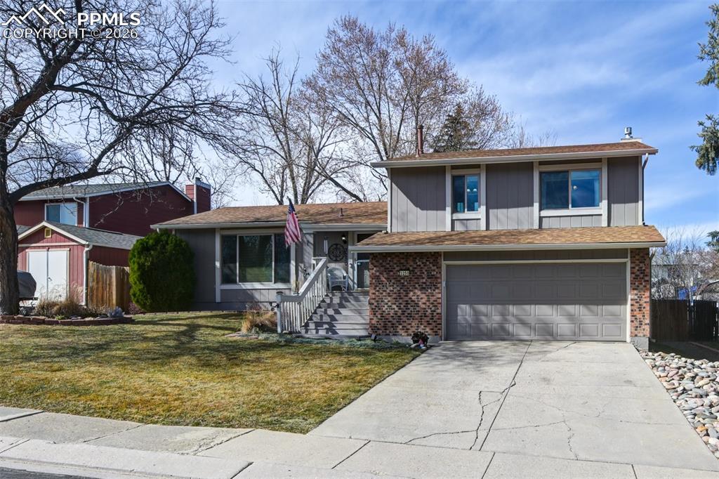 Image 6 of 41: View of front of house featuring driveway, brick siding, an attached garage