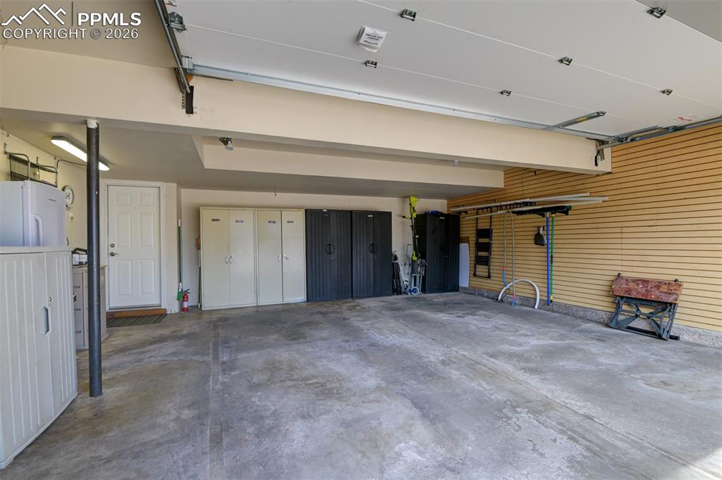 Image 8 of 41: Garage featuring freestanding refrigerator