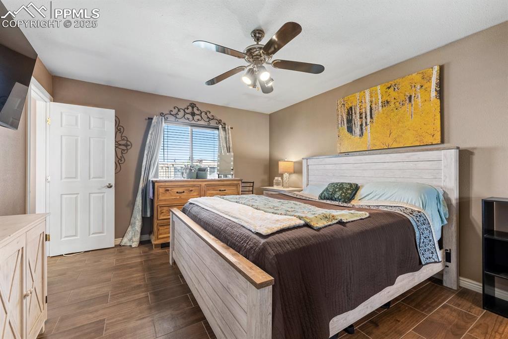 Image 13 of 39: Bedroom featuring dark wood-style tile floors.