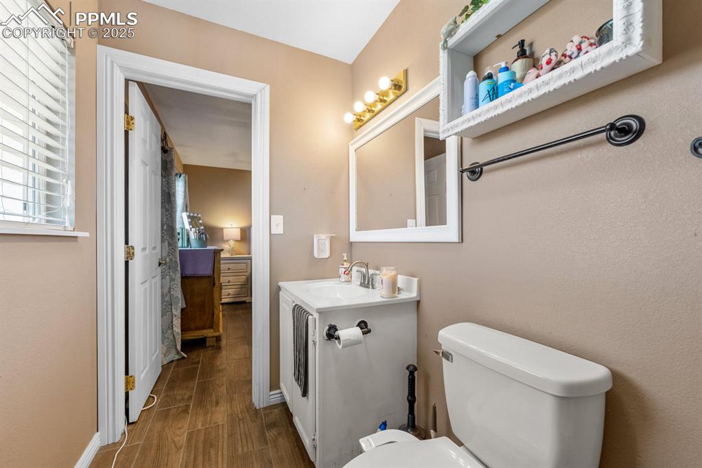 Image 14 of 39: Bathroom with vanity, wood finished floors, toilet, and baseboards