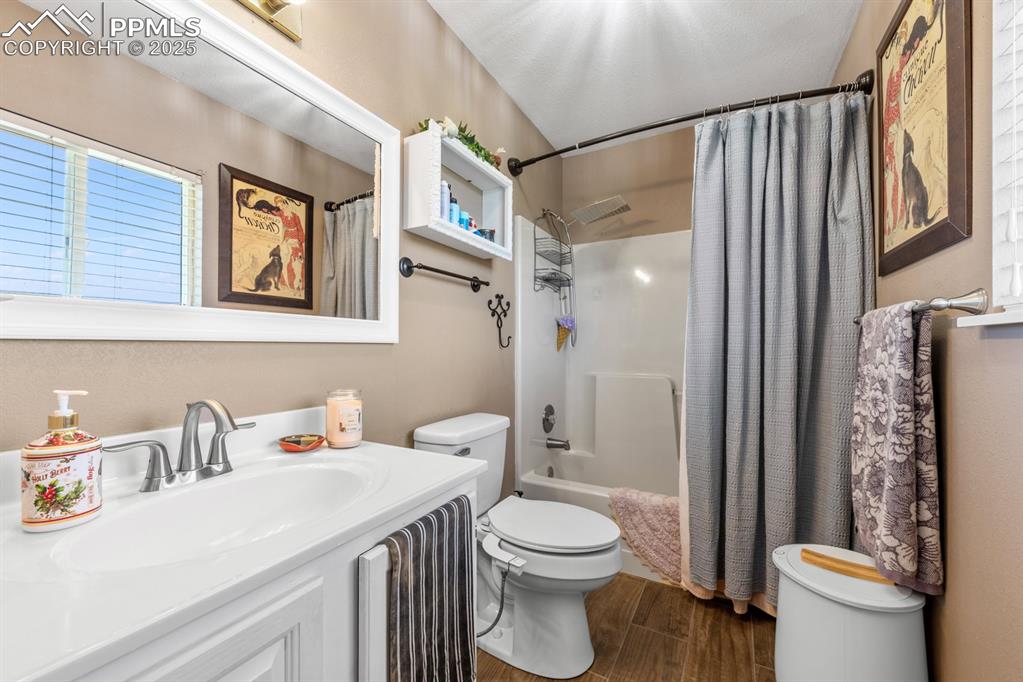 Image 15 of 39: Bathroom with toilet, wood finished floors, vanity, and shower / bath combo