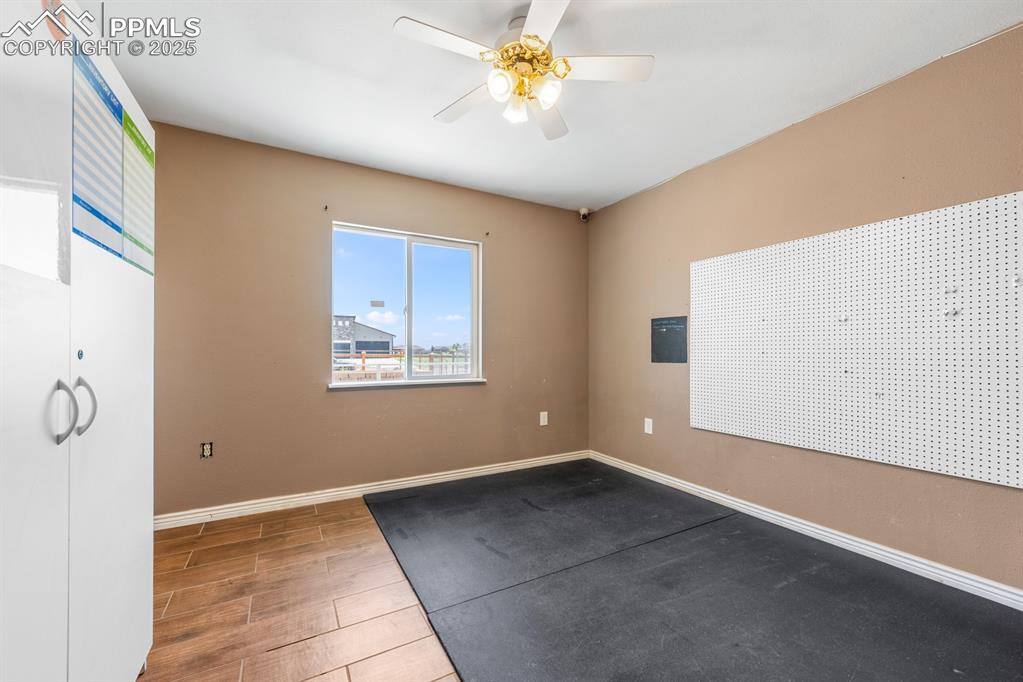 Image 17 of 39: Room with a ceiling fan, baseboards, and wood finished floors