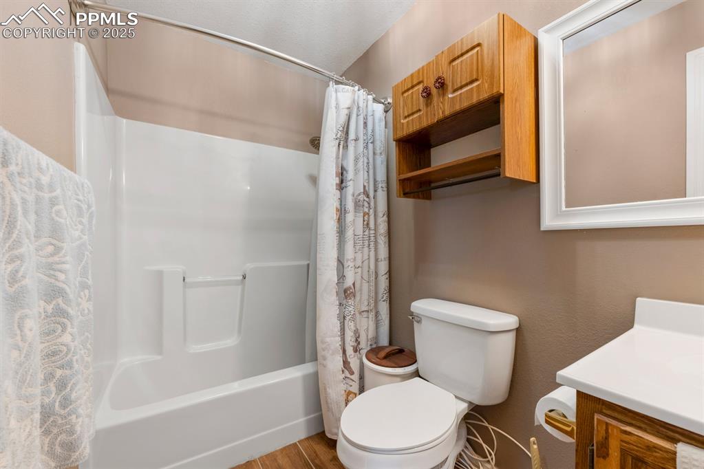 Image 19 of 39: Full bathroom with vanity, shower / bathtub combination with curtain, toile