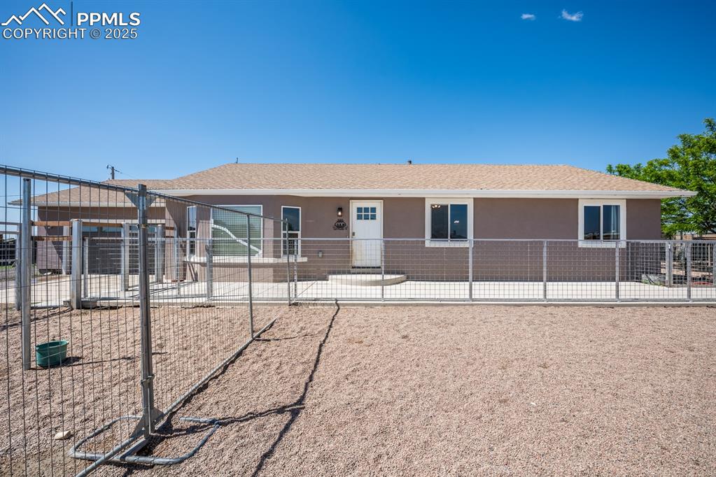 Image 2 of 39: View of front of property with stucco siding and a patio from inside the fu