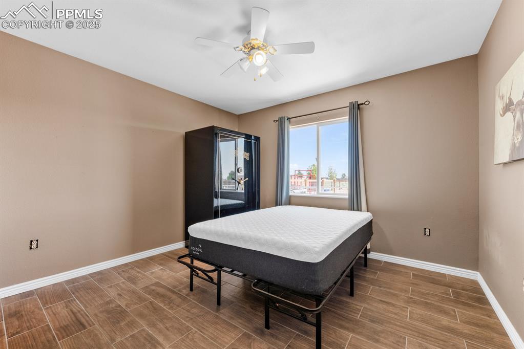 Image 21 of 39: Bedroom featuring wood tiled floors, baseboards, and ceiling fan