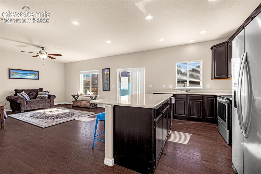Image 14 of 45: Open-concept living space featuring wood-finish flooring, recessed lighting