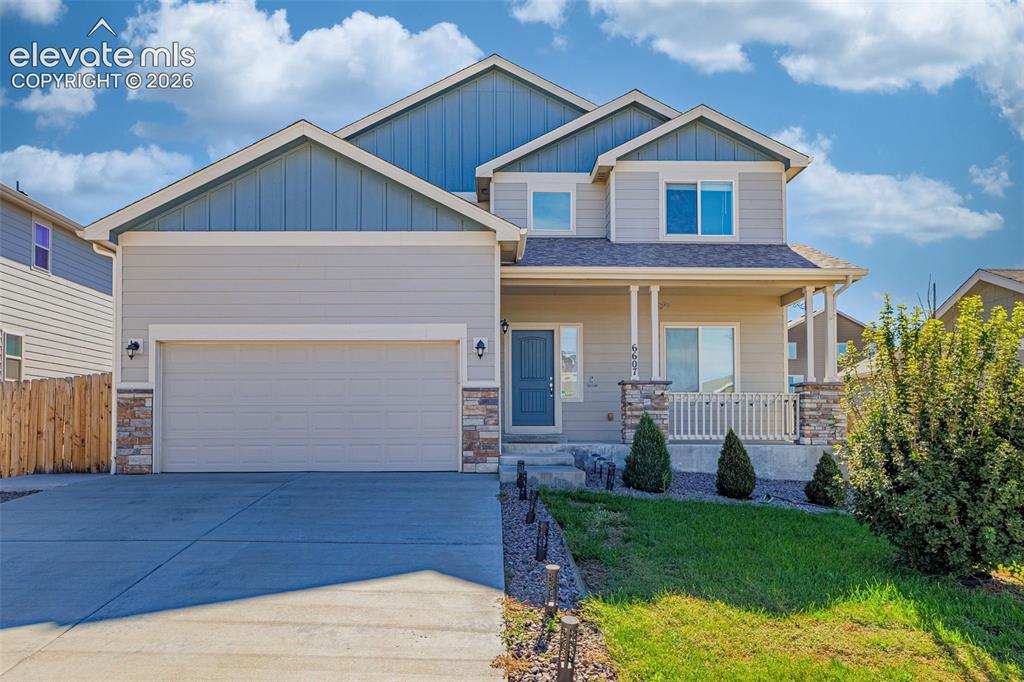 Image 2 of 45: Two-story residence featuring a covered entry porch, an attached garage, an