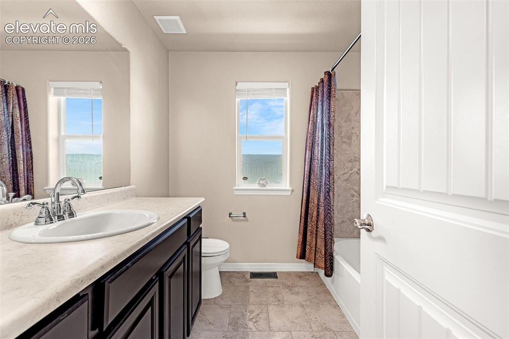 Image 20 of 45: Vanity with integrated sink, dark wood-finish cabinetry, and chrome fixture