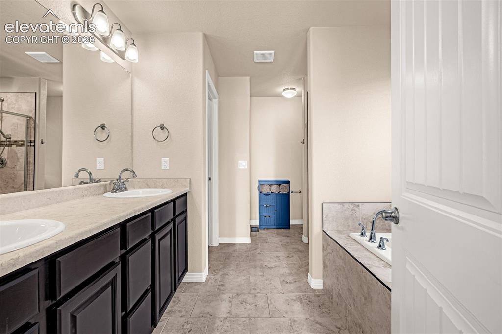 Image 22 of 45: Dual vanity with integrated sinks, brushed nickel fixtures, and dark wood-f
