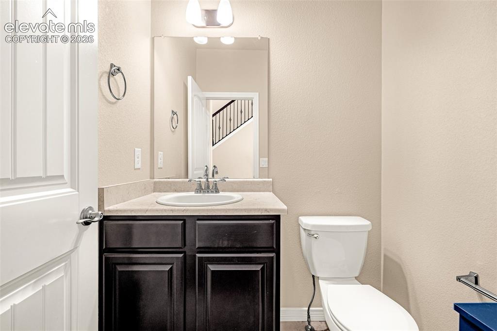 Image 28 of 45: Recessed sink with a chrome faucet, dark wood-finish cabinetry, light-toned