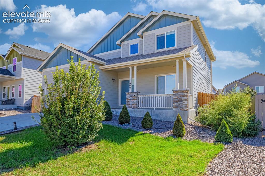 Image 3 of 45: Two-story exterior with siding, a covered front porch, stone-accented colum