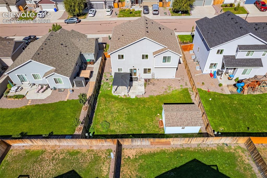 Image 37 of 45: Expansive backyard featuring a manicured lawn, established privacy fencing,