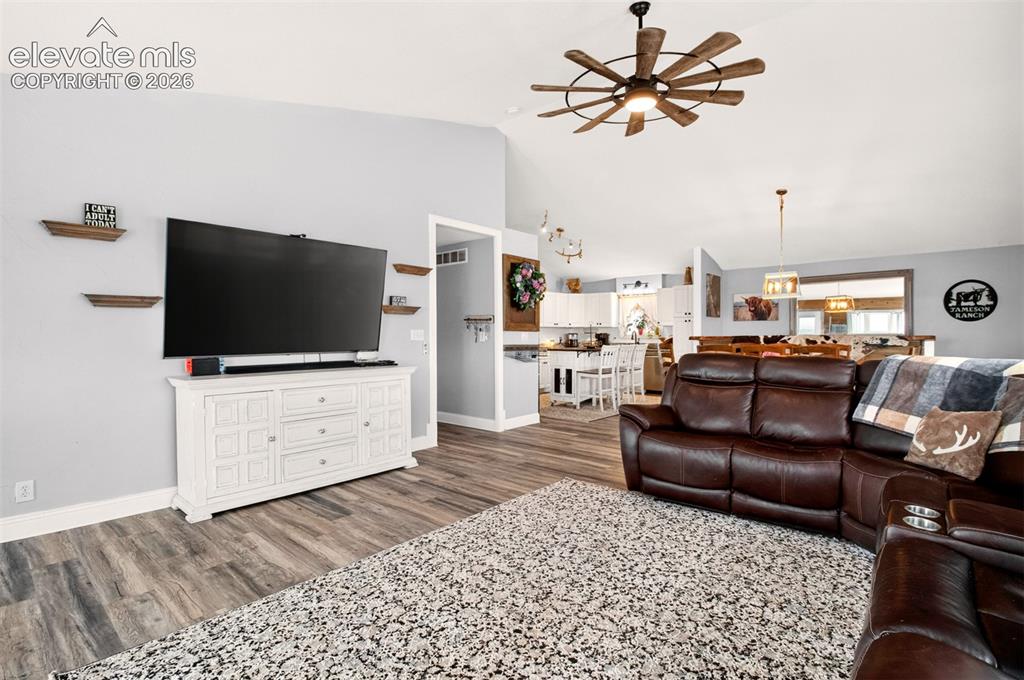 Image 14 of 50: Bright living room featuring soaring vaulted ceilings, large windows, and a