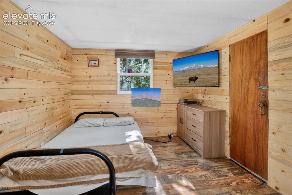 Image 12 of 39: Roomy bedroom with beautiful wood paneling