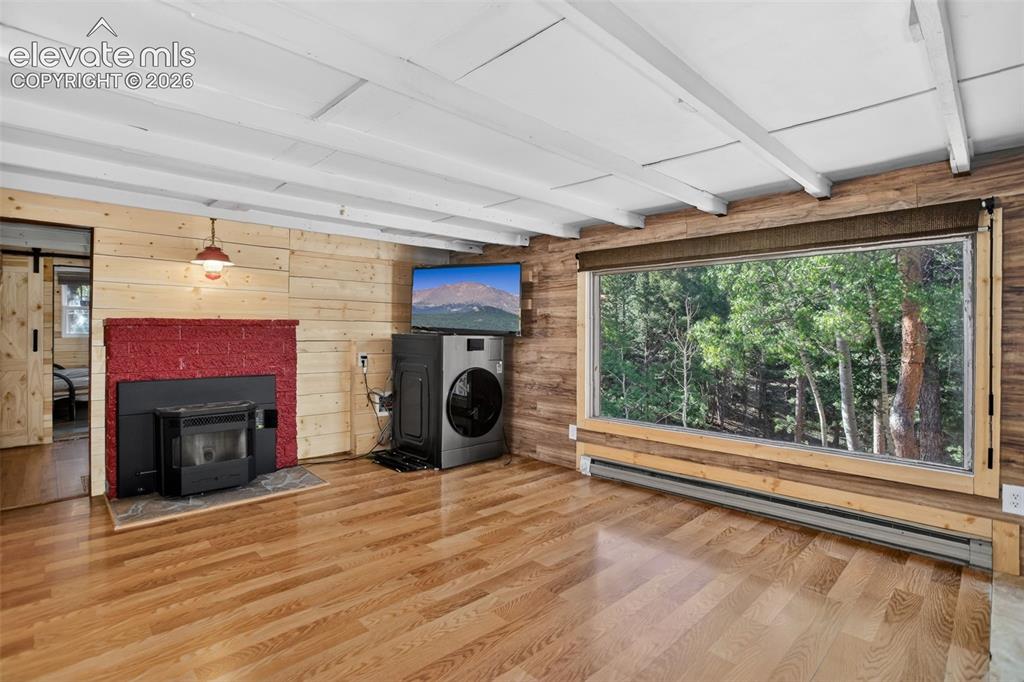 Image 6 of 39: Living room with large picture window captures the view!