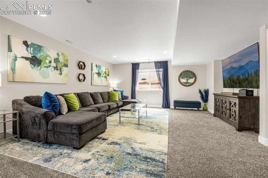 Image 21 of 35: Carpeted living area with baseboards and recessed lighting