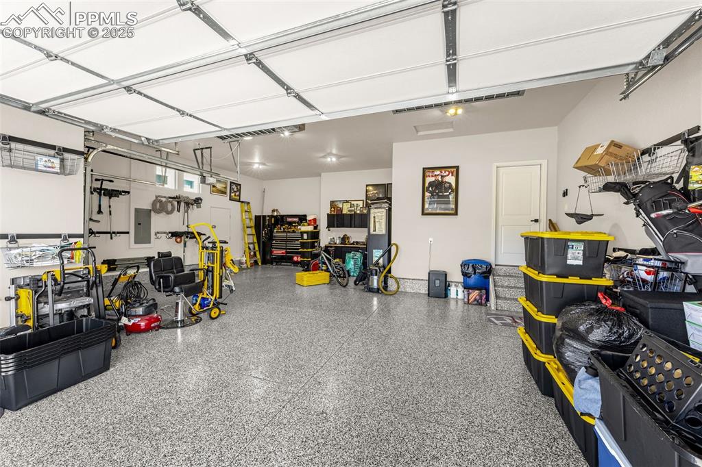 Image 26 of 35: Extended 3 car + Epoxy floor + motorized ceiling racks that lower + cabinet