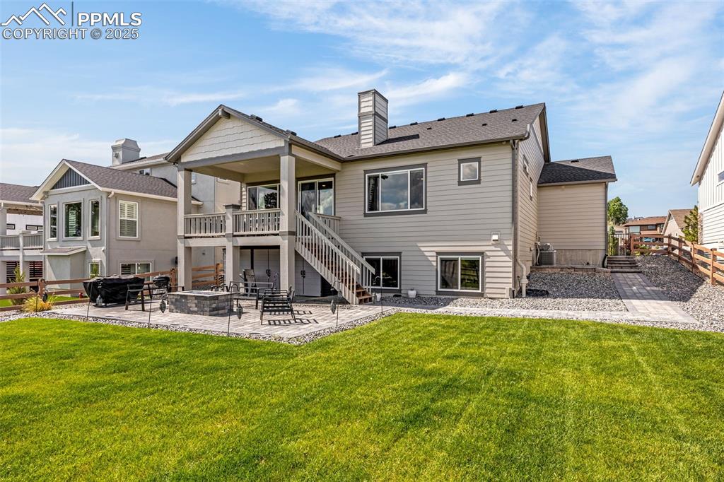 Image 29 of 35: Back of house with a patio area, stairs, a fenced backyard, a chimney, and 